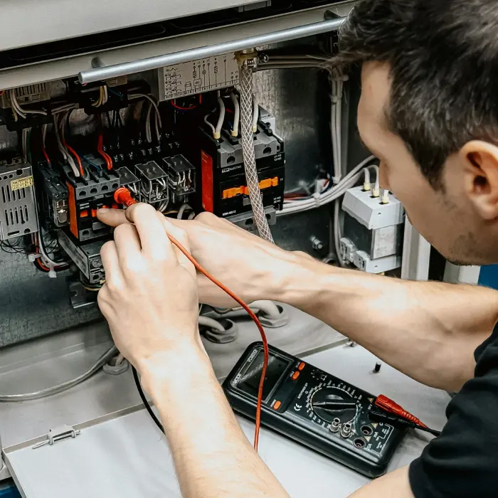 Electricista profesional brindando mantenimiento a una instalación eléctrica